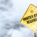 Winter Storm Warning Sign With Snowfall and Stormy Background