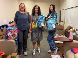 Employees display donated backpacks