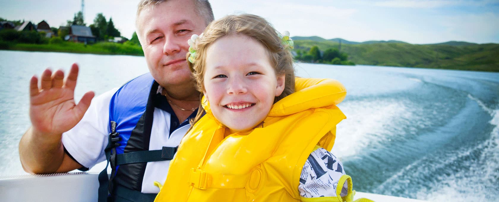 father and daughter with life jackets in boat