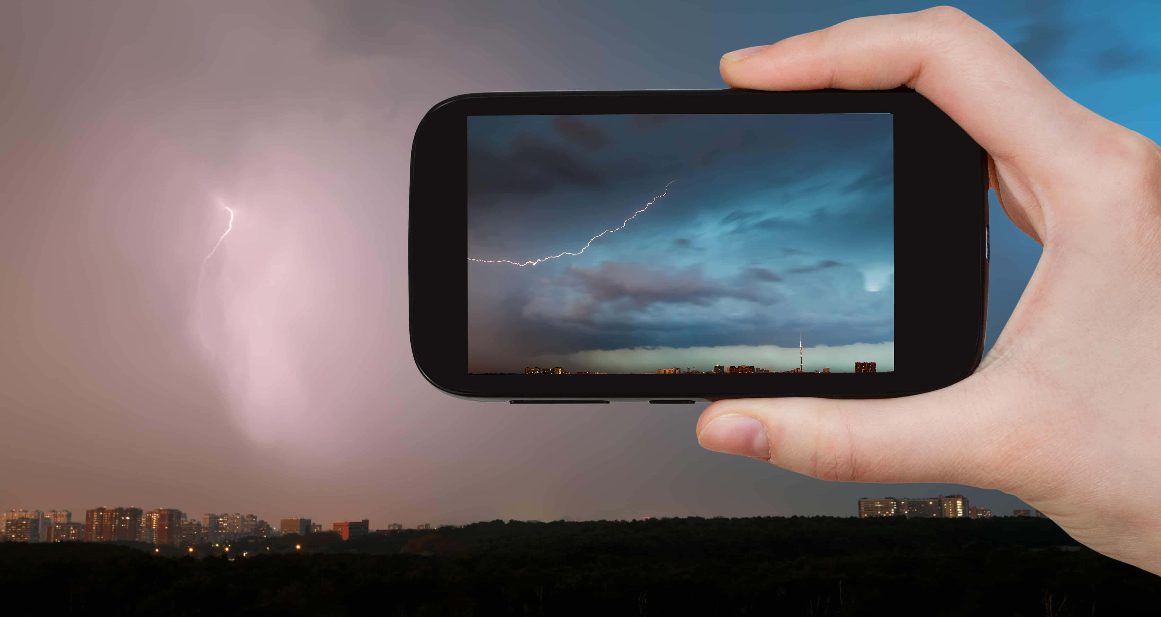 Smartphone taking a photo of a thunderstorm