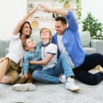Family enjoying playful moment on living room floor, symbolizing home safety and protection with Tower Hill Insurance.