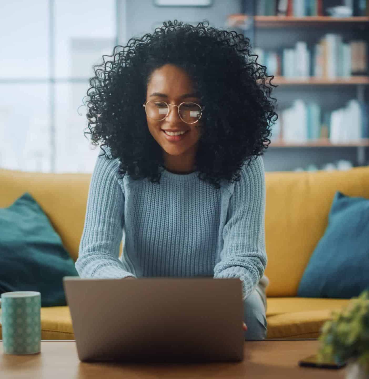 Woman working on laptop on sofa